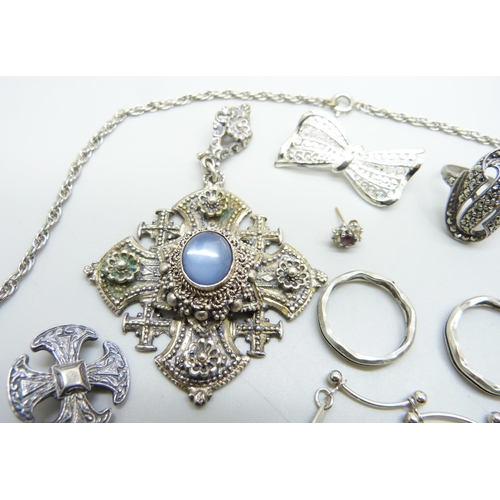 883 - A large stone set cross pendant, a silver cross brooch, a silver ring, etc.