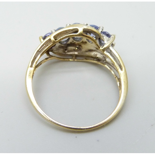 915 - A silver gilt ring set with tanzanite and diamond accents, M