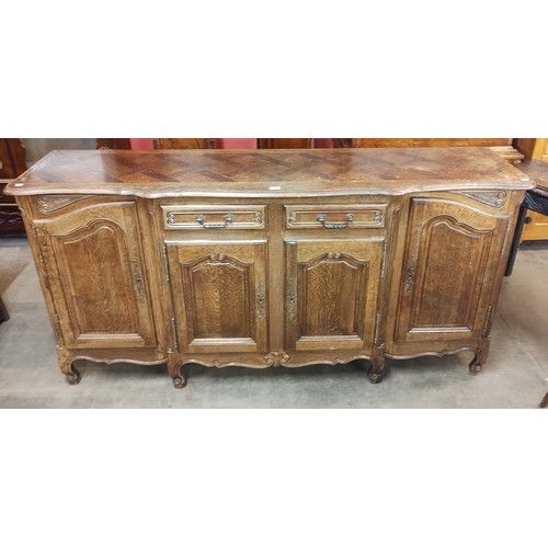 122 - A 19th century style French Breton carved oak four door sideboard