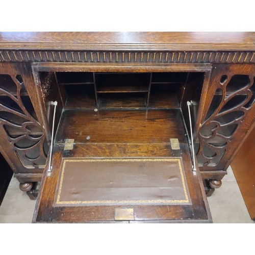 127 - An early 20th Century carved oak side by side bureau bookcase