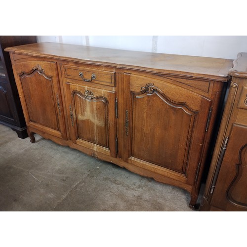 143 - An 18th Century style French Breton carved oak three door sideboard