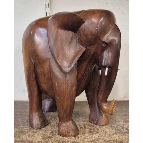 364 - An African carved teak figure of an elephant, with faux ivory tusks