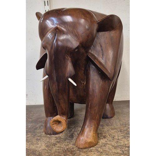 364 - An African carved teak figure of an elephant, with faux ivory tusks