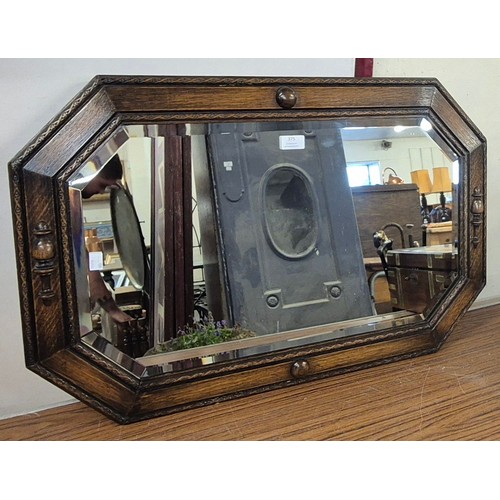 375 - An early 20th century carved oak octagonal framed mirror