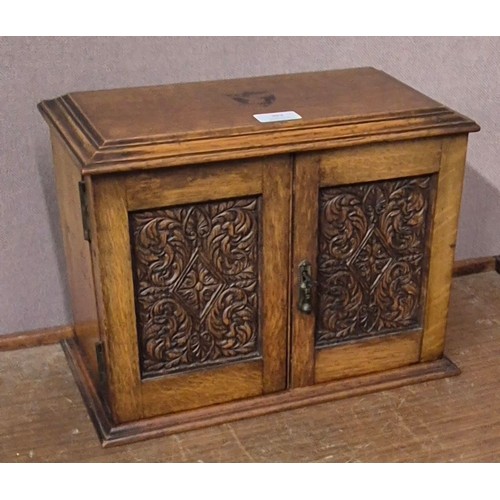 392 - A Victorian carved oak smokers cabinet