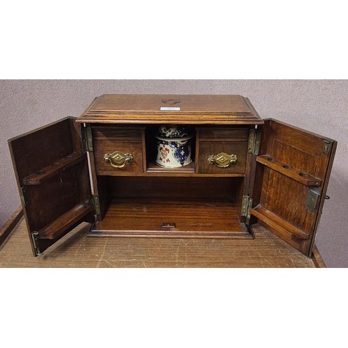 392 - A Victorian carved oak smokers cabinet