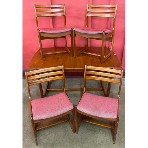 40 - A Portwood teak extending dining table and four chairs