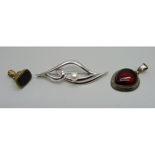 1008 - A silver mounted pendant, a silver and cultured pearl brooch, and a brass seal fob