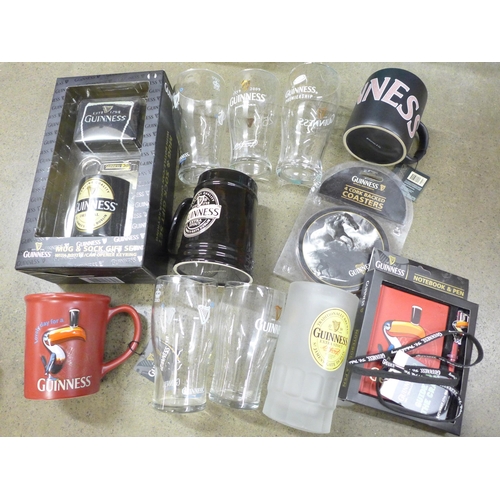 1028 - A box of Guinness memorabilia, three mugs, Notepad & pen, coasters, a sock gift set, etc. **PLEASE N... 