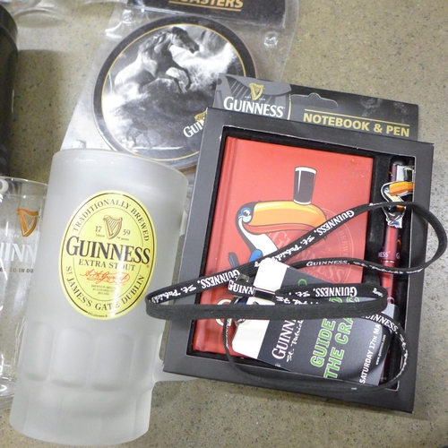 1028 - A box of Guinness memorabilia, three mugs, Notepad & pen, coasters, a sock gift set, etc. **PLEASE N... 