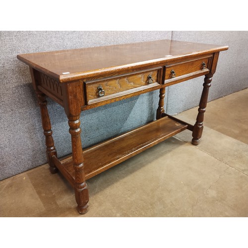 102 - An 18th Century style carved oak two drawer serving table