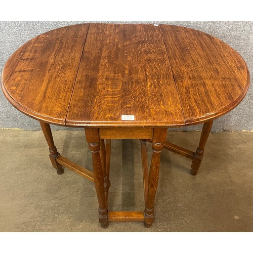 156 - An early 20th Century oak bobbin turned gateleg table and a pair of Art Deco oak dining chairs