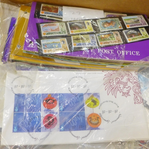 712 - A box of mixed first day covers, stamps, presentation packs, etc., also noted some USA stamps, an al... 