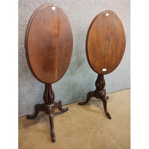 114 - A pair of Victorian walnut oval tilt top tripod tables