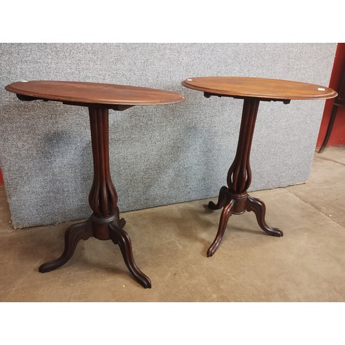 114 - A pair of Victorian walnut oval tilt top tripod tables