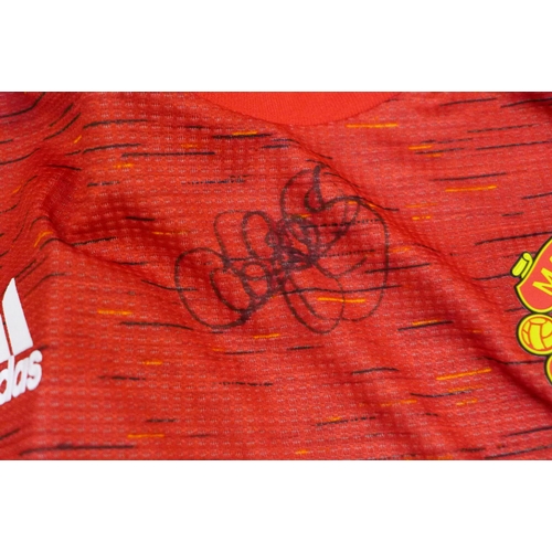 736 - A replica 1980's England football shirt signed by Bryan Robson, also a signed DVD and a signed Manch... 