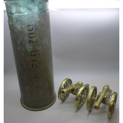 767 - A brass shell case and two brass model cannons