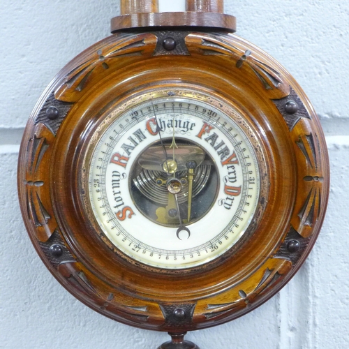 781 - A carved walnut wall barometer