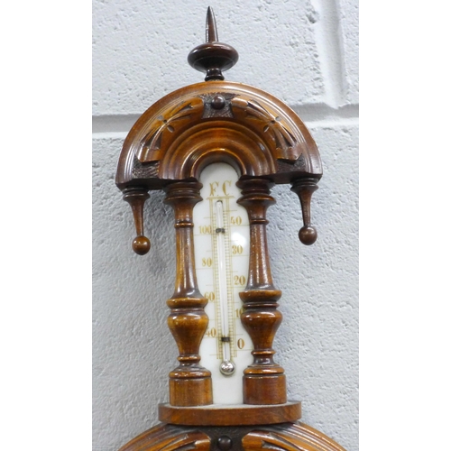 781 - A carved walnut wall barometer