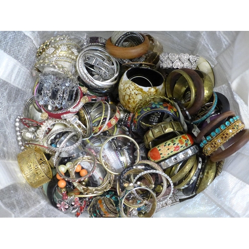 793 - A large bag of bangles - costume jewellery and new costume jewellery