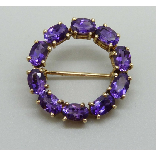 883 - A yellow metal and amethyst set brooch, indecipherable ct stamp, 4.8g, 2.4cm