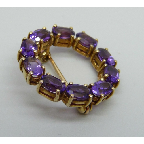 883 - A yellow metal and amethyst set brooch, indecipherable ct stamp, 4.8g, 2.4cm