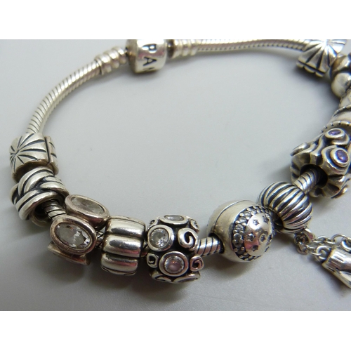 938 - A silver Pandora bracelet with 12 charms and stoppers, 50g