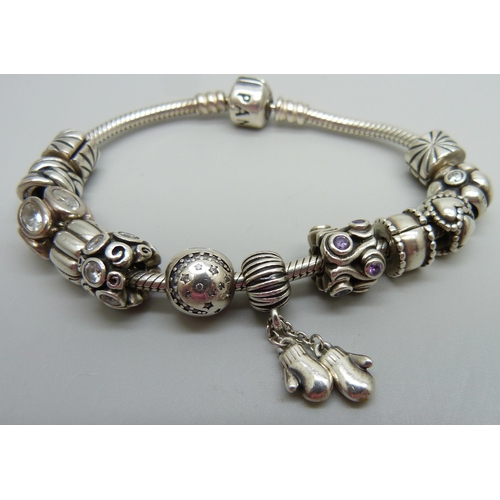 938 - A silver Pandora bracelet with 12 charms and stoppers, 50g