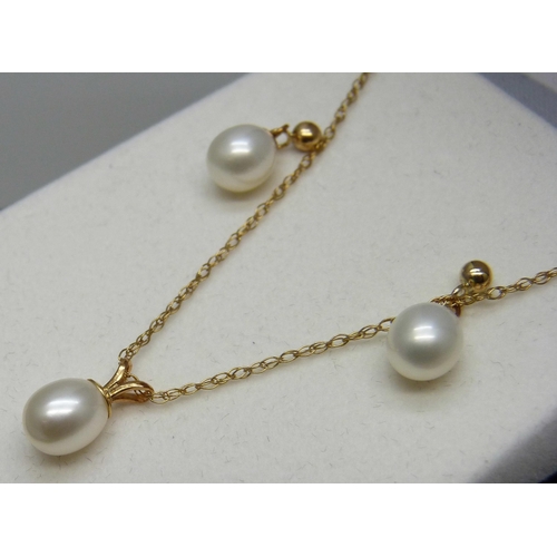 961 - A fine 9ct gold chain with a yellow metal set pearl pendant, and a pair of yellow metal and pearl ea... 