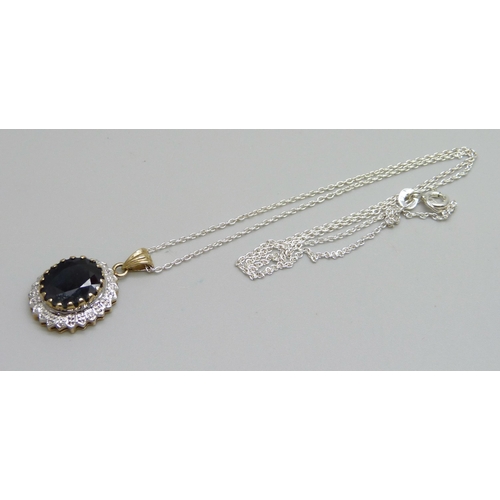 975 - A 9ct gold pendant set with a sapphire, 3.5g, on a silver chain