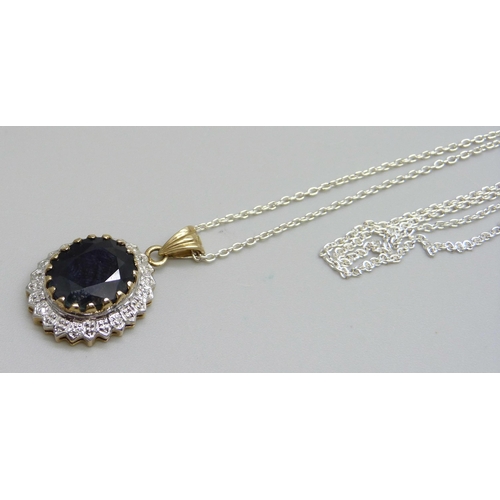 975 - A 9ct gold pendant set with a sapphire, 3.5g, on a silver chain