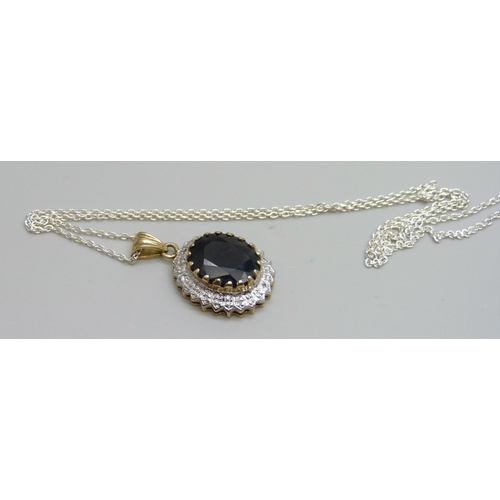 975 - A 9ct gold pendant set with a sapphire, 3.5g, on a silver chain