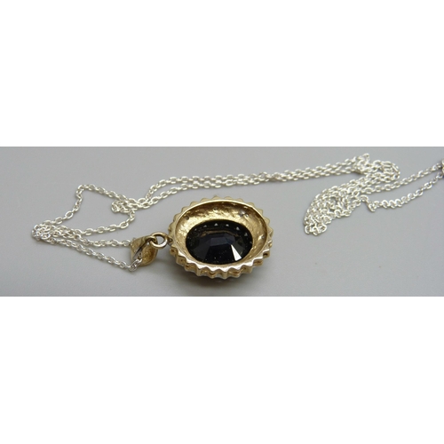 975 - A 9ct gold pendant set with a sapphire, 3.5g, on a silver chain