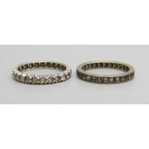 976 - Two white metal eternity rings, both size N, one marked 9ct, 3.7g total