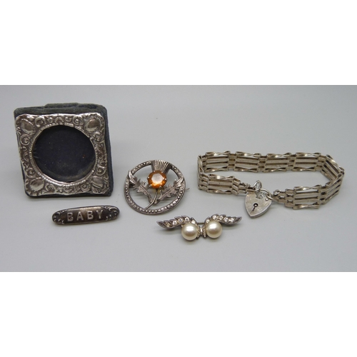 990 - A miniature Silver photograph frame, a silver gate bracelet and three silver brooches (faux pearl br... 