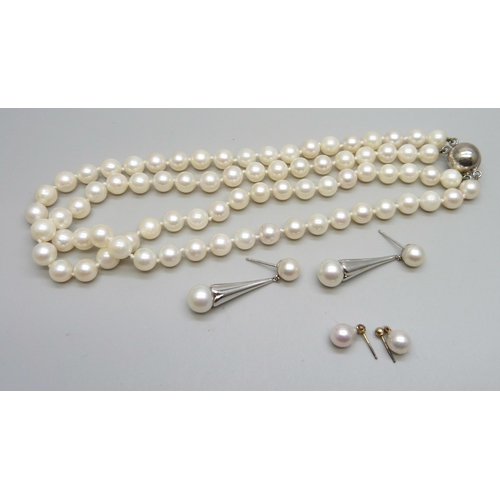 999 - A double row of cultured pearls on a silver clasp, a pair of white metal mounted pearl earrings, and... 