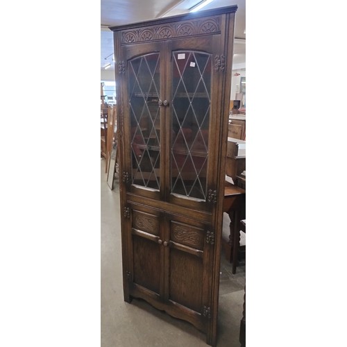 123 - A carved oak freestanding corner cabinet