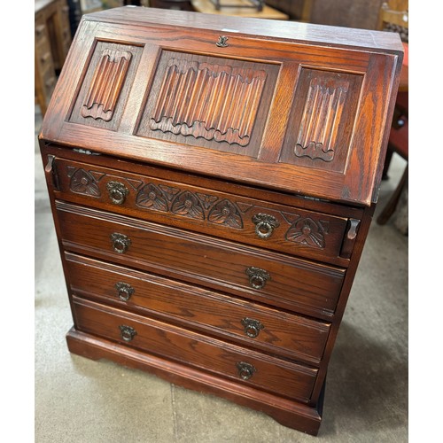 194 - An early 20th Century carved oak linenfold bureau