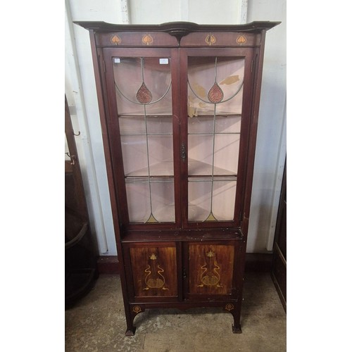 253 - An Arts and Crafts inlaid mahogany freestanding corner cabinet