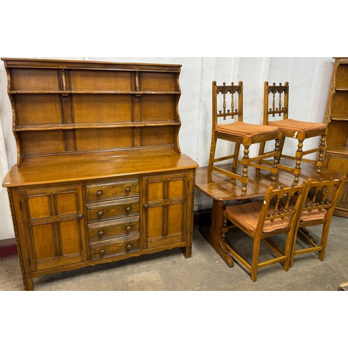 255 - An Ercol Golden Dawn elm dining suite, comprising; refectory table, four chairs and a dresser