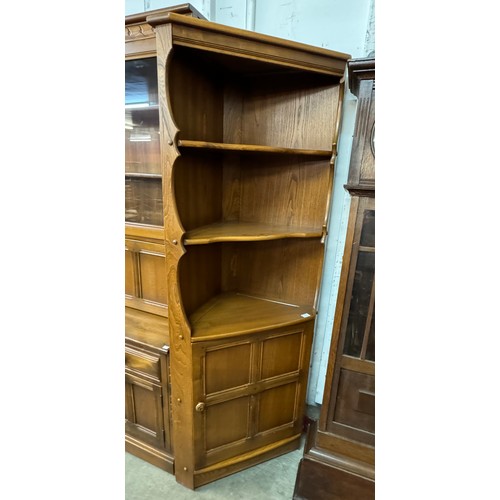 256 - An Ercol Golden Dawn elm bookcase and a freestanding corner cupboard