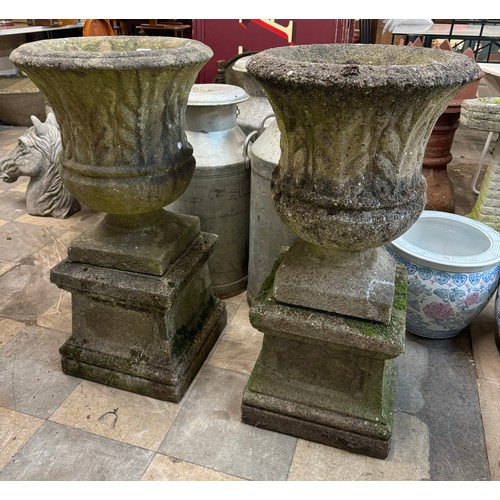 268 - A pair of reconstituted stone campana shaped garden urns on stands