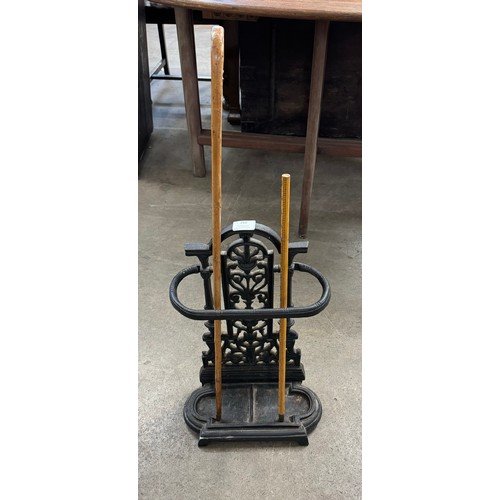 259 - A Victorian cast iron stick stand and two walking sticks