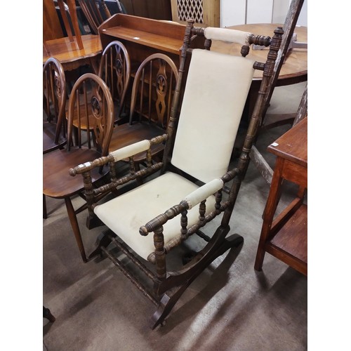 215 - An early 20th Century American beech and fabric upholstered rocking chair