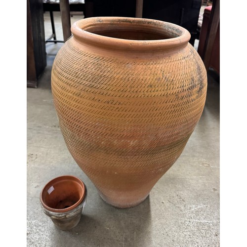 262 - An Italian terracotta olive jar and two small plant pots