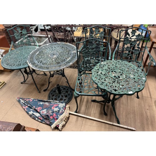 284 - Three cast alloy garden tables, four chairs and an umbrella stand