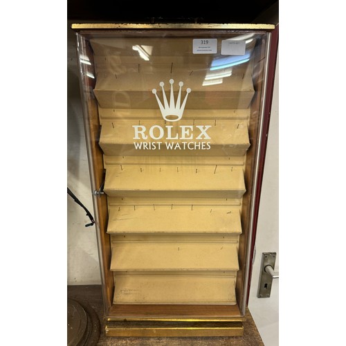 319 - An beech revolving watch display cabinet bearing Rolex and Omega inscription