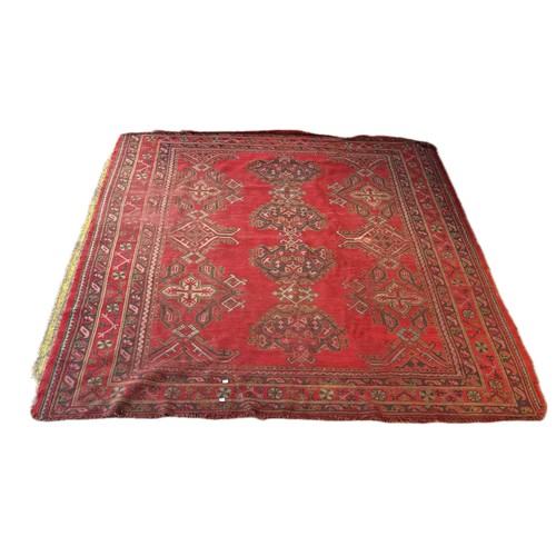 188 - An eastern red ground rug (255cm x 220cm)