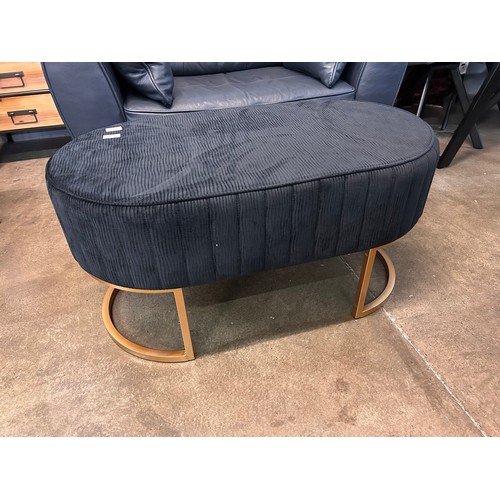 3023A - A black oval footstool with gold legs