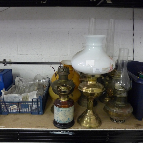 5041 - A collection of nine vintage pressure lamps and a quantity of assorted lamp glasses